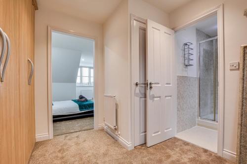 ein Bad mit ebenerdiger Dusche neben einer Tür in der Unterkunft Elegant Bolton Abode - Sleeps 10 in Bolton