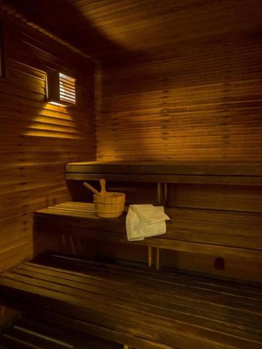 a wooden sauna with a basket of towels on a bench at 2Home Stockholm South in Stockholm