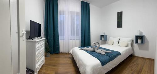 a bedroom with a bed with two stuffed animals on it at Diva Apartments in Satu Mare