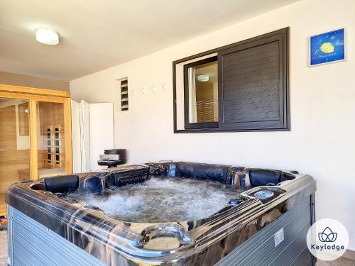 a large bath tub filled with water in a room at Villa Marie France - avec jacuzzi et sauna - Plaine des Cafres in Le Tampon