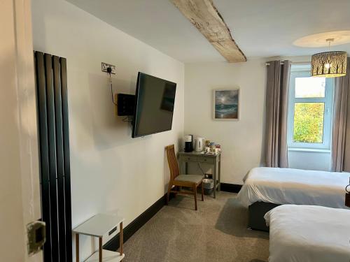 a hotel room with two beds and a television at Lochaline Hotel in Lochaline