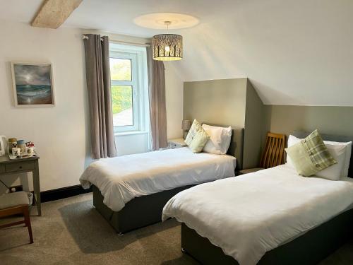 a hotel room with two beds and a chandelier at Lochaline Hotel in Lochaline