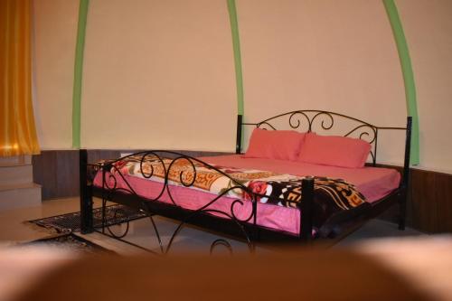 a bed with pink and orange pillows in a room at LaCliff Nature Home in Dhanaulti