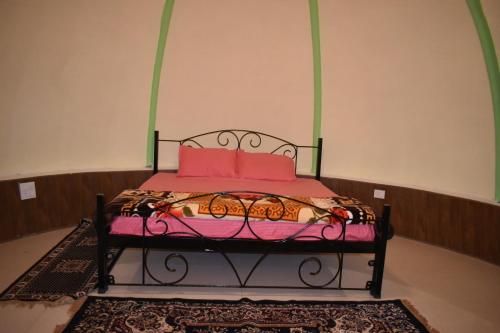 a bedroom with a bed with pink pillows at LaCliff Nature Home in Dhanaulti