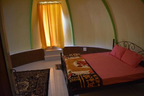 1 dormitorio con cama y ventana con cortina en LaCliff Nature Home, en Dhanaulti