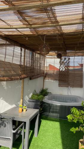 um pátio com uma mesa e uma banheira de hidromassagem em Ara Access em Cotonou
