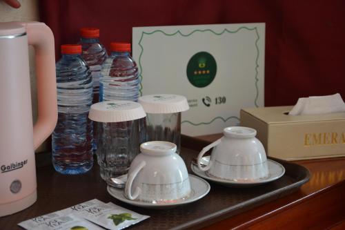 巴庫的住宿－EmeraldGold，一张桌子,上面放着两盘碗碟和瓶装水