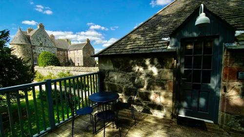 a deck with two chairs and a castle in the background at The Lodges @ Barra Castle in Inverurie
