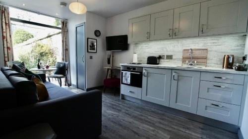 a kitchen with white cabinets and a couch in a room at The Lodges @ Barra Castle in Inverurie
