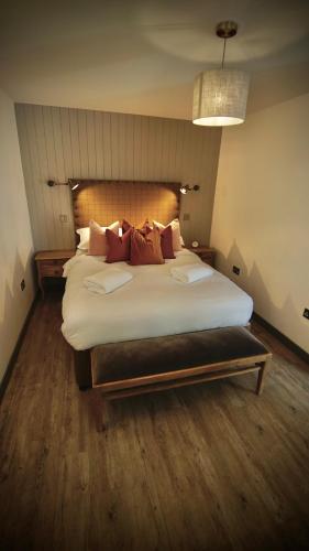 a bedroom with a large bed with white sheets and pillows at The Lodges @ Barra Castle in Inverurie