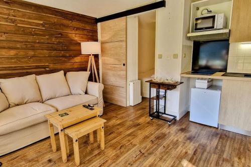 a living room with a couch and a table at Au petit Payolle - Appartement type Chalet sur le Lac de Payolle in Campan