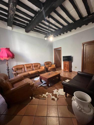 a living room with leather couches and a table at Locanda Del Duca in Gubbio