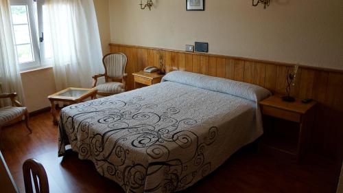 1 dormitorio con 1 cama y 1 silla en Hotel Larry en Cee