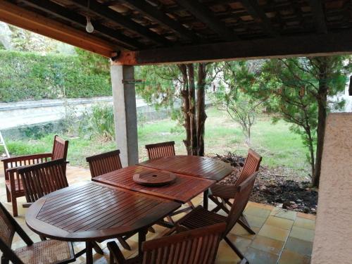 une table et des chaises en bois sur une terrasse dans l'établissement Maison Toulon ouest, à Toulon