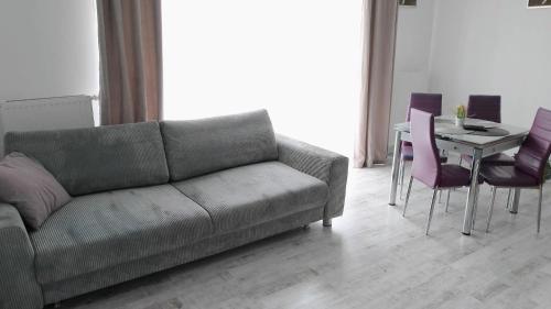 a living room with a couch and a table with chairs at Apartament na Kruczej in Lubin