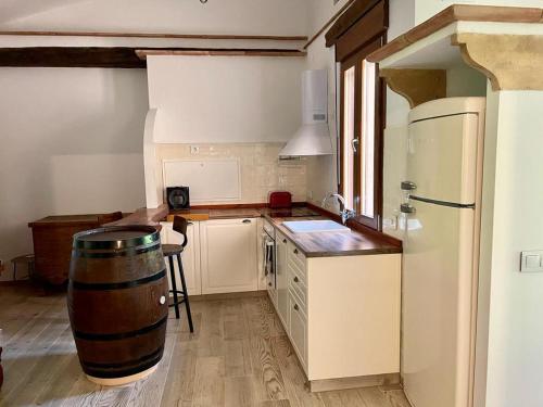 a kitchen with a barrel in the middle of it at Cortijo la Noria II in Puebla de Don Fadrique