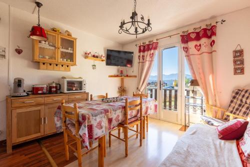 une salle à manger avec une table et un balcon dans l'établissement Le Cocon des Angles - Proche station de ski, aux Angles
