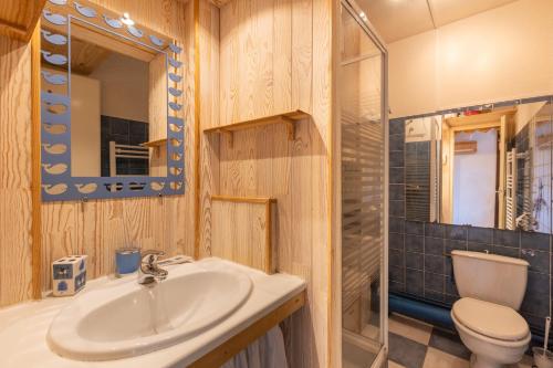 une salle de bain avec un lavabo, des toilettes et un miroir dans l'établissement Le Cocon des Angles - Proche station de ski, aux Angles