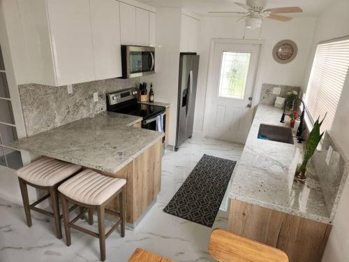 a kitchen with a counter and stools in a room at Charming Home Away From Home in Fort Lauderdale