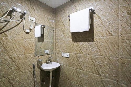 Hotel Olive New Delhi في نيودلهي: حمام مع حوض ومرآة