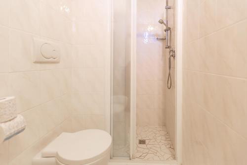 a white bathroom with a shower with a toilet at Hotel Globus in Rimini