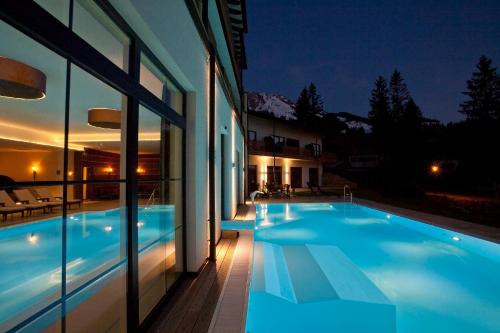 una casa con piscina di notte di Panoramahotel Oberjoch a Bad Hindelang