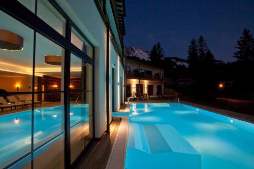 ein Haus mit Pool in der Nacht in der Unterkunft Panoramahotel Oberjoch in Bad Hindelang
