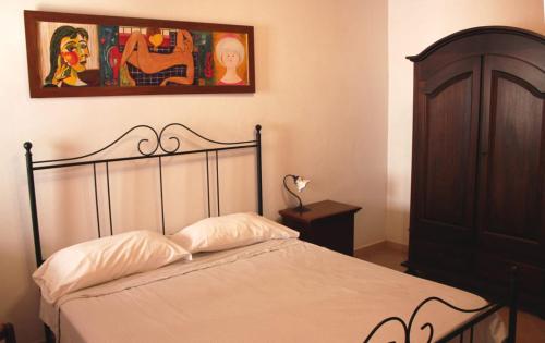 1 dormitorio con 1 cama y una pintura en la pared en Kamikos Casa Vacanze, SICULIANA, en Siculiana