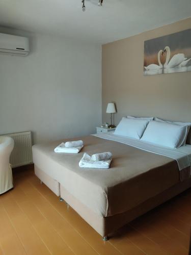 a bedroom with a large bed with two towels on it at Bozikis House! A cosy apartment in the city centre in Skiathos