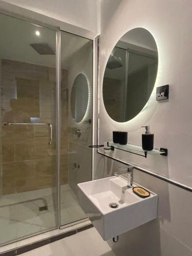 a bathroom with a sink and a shower and a mirror at Mos retreat in Lagos