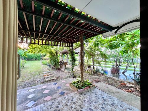 an outside view of a patio with a pergola at MrT Riverside Sampran มิสเตอร์ที โฮมสเตย์-ริมนที in Sam Phran