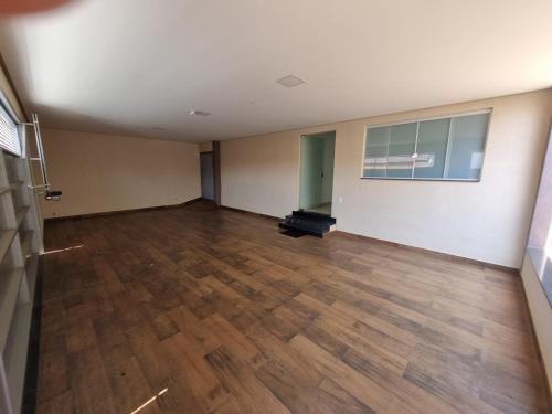 ein leeres Zimmer mit Holzböden und einem Zimmer mit Fenster in der Unterkunft Casa de temporada in Piuí