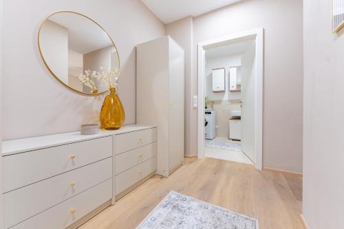 a white room with a dresser and a mirror at Garden.Suite am Steinertor in Krems an der Donau