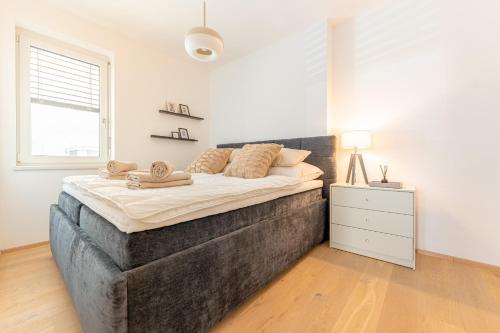 una camera da letto con un grande letto in una stanza bianca di Garden.Suite am Steinertor a Krems an der Donau
