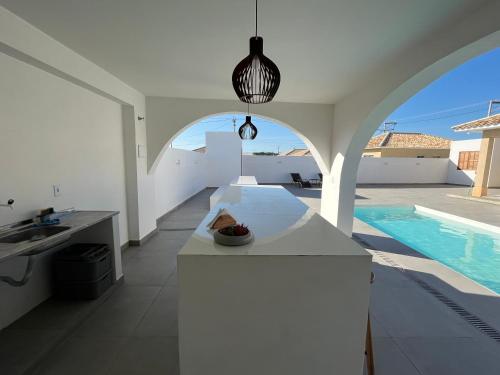 a white kitchen with a sink and a swimming pool at Casa nova - Praia Linda, São Pedro da Aldeia in Iguaba Grande