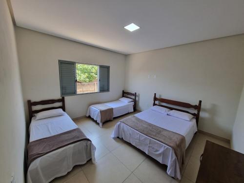 um quarto com 2 camas e uma janela em Casa de temporada em Piumhi