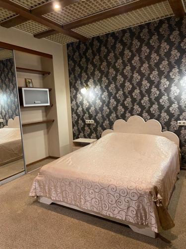 a bedroom with a bed and a tv on the wall at Hotel Verona in Novokuznetsk