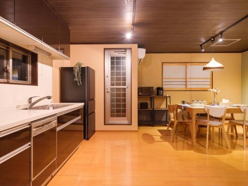 eine Küche mit einem Tisch und einem Esszimmer in der Unterkunft Muji Arashiyama Villa 無時嵐1階2階賃貸し 駅まで徒歩2分 in Kyoto
