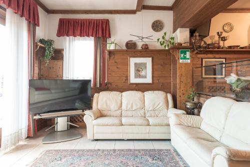 a living room with a couch and a piano at Hotel Vescovi in Asiago