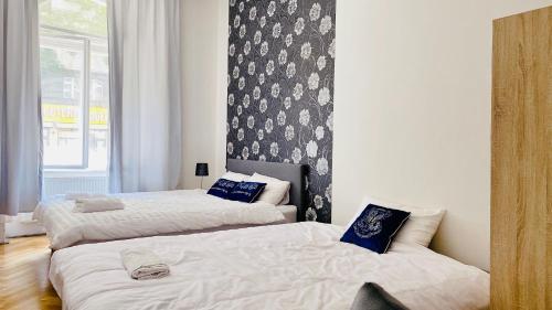 a bedroom with two beds and a wall with a window at Hotel Room in Praha 2 Square in Prague