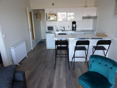 - une cuisine avec 4 chaises et un comptoir dans l'établissement Charmant T2 tout confort Cabourg, à Cabourg