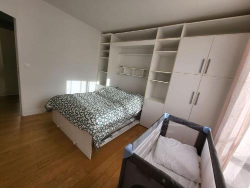 Schlafzimmer mit einem Bett und weißen Schränken in der Unterkunft T2 charmant rue de Commerce in Paris