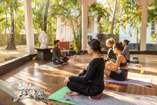 un grupo de personas sentadas en una clase de yoga en Feather Touch Hotels and Resorts Palolem, en Palolem