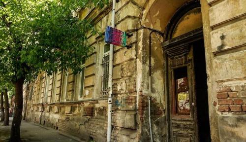 uma bandeira ao lado de um edifício de pedra em Four Season em Tbilisi