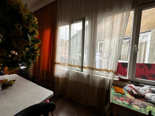 um quarto com uma mesa e uma janela com cortinas em Four Season em Tbilisi
