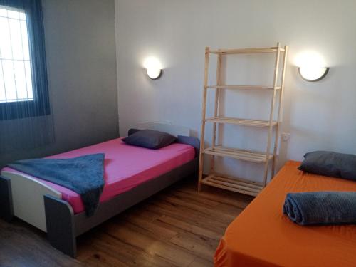 a room with two beds and a book shelf at Maison individuelle plain pied avec Spa en option in Perpignan