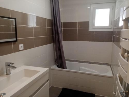 La salle de bains est pourvue d'une baignoire, d'un lavabo et d'une douche. dans l'établissement Maison individuelle plain pied avec Spa en option, à Perpignan