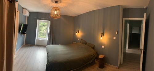 een slaapkamer met een bed in de hoek van een kamer bij Le gîte de Moulinas in Giffon
