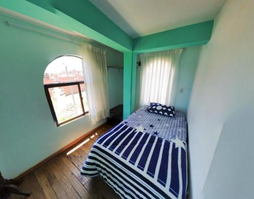 a bedroom with a bed in a room with a window at Casa Hostel Sauta Suite in Copacabana