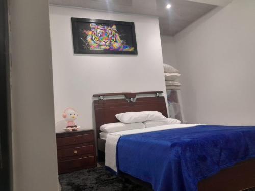 ein Schlafzimmer mit einem Bett und einem Wandgemälde in der Unterkunft DESCANSO EN SUTATENZA BOYACA in Sutatenza